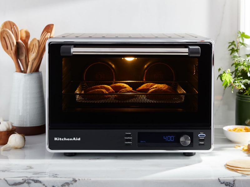 Empanadas cooking inside a black KitchenAid® countertop oven Empanadas cooking inside a black KitchenAid® countertop oven