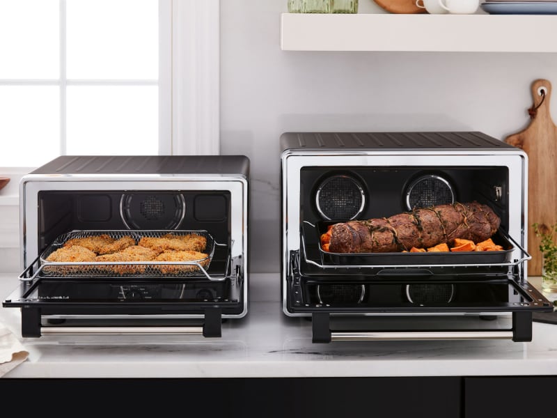 Two countertop ovens side-by-side featuring different meals Two countertop ovens side-by-side featuring different meals
