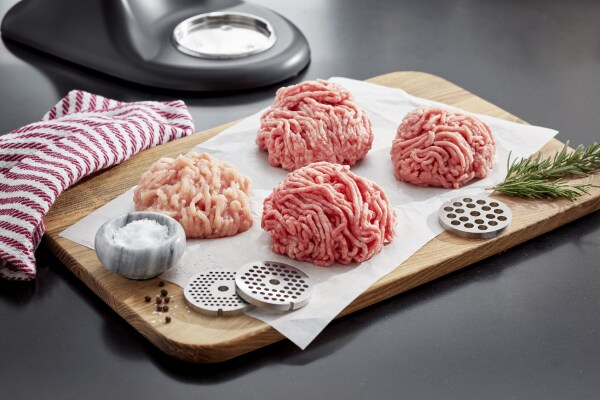 Piles of ground meat on a wooden cutting board