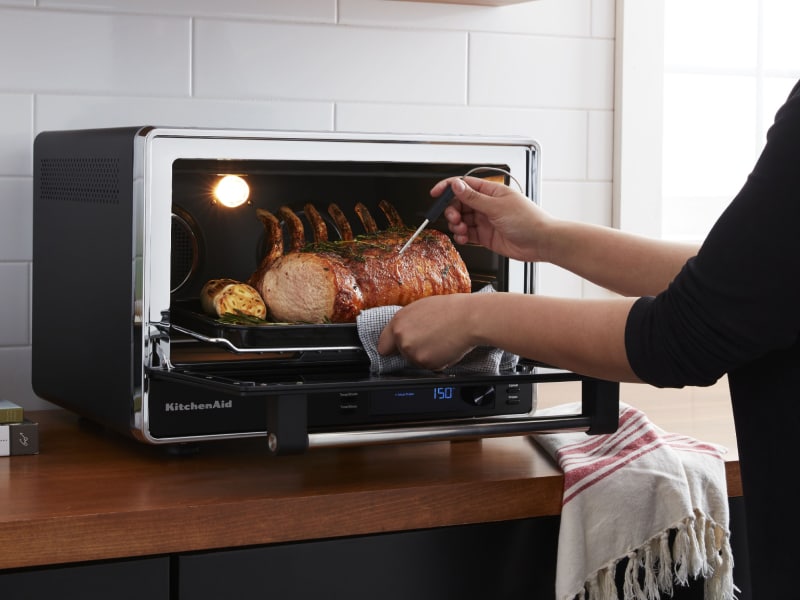 A pork roast being removed from a KitchenAid® Countertop Oven A pork roast being removed from a KitchenAid® Countertop Oven