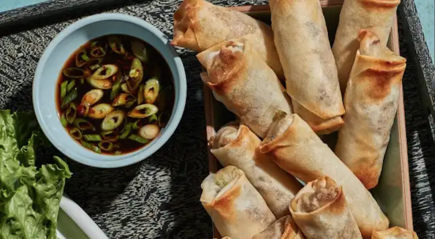 Same as Image Alt Text Egg rolls on dish next to dip.