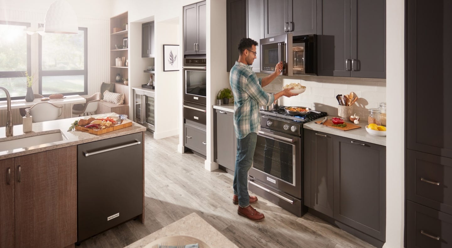 Person using microwave in modern kitchen Person using microwave in modern kitchen