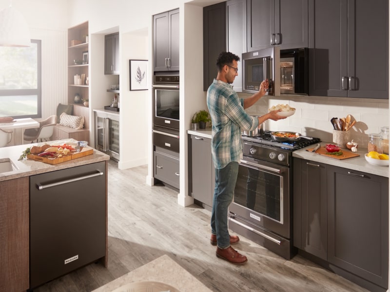 Person using microwave in modern kitchen