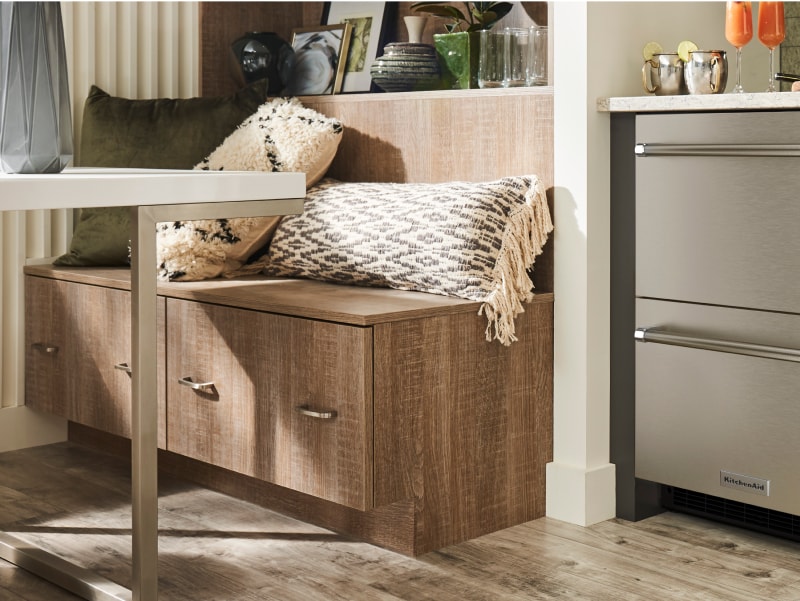 Breakfast nook next to KitchenAid® stainless steel undercounter refrigerator drawers
