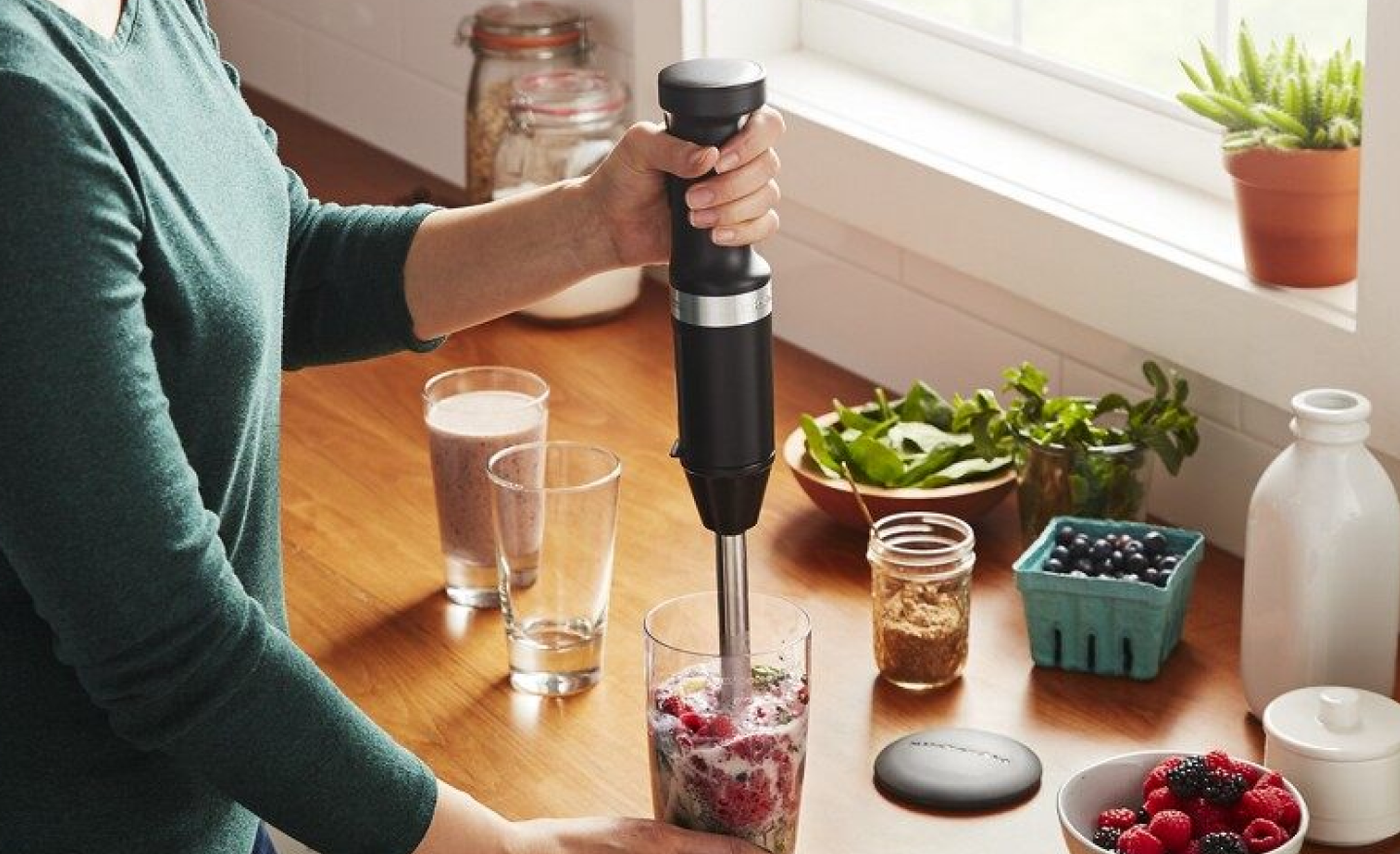Woman blending a smoothie in a drinking glass Woman blending a smoothie in a drinking glass