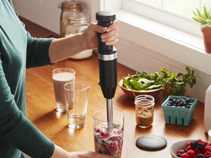 Woman blending a smoothie in a drinking glass Woman blending a smoothie in a drinking glass