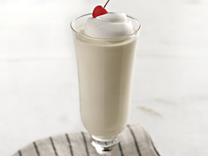 Vanilla milkshake with whipped cream and a cherry on top Vanilla milkshake with whipped cream and a cherry on top