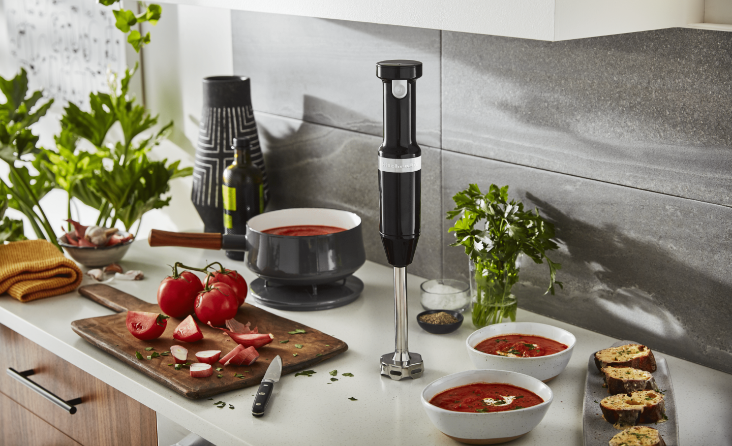Tomato soup cooking next to an immersion blender Tomato soup cooking next to an immersion blender