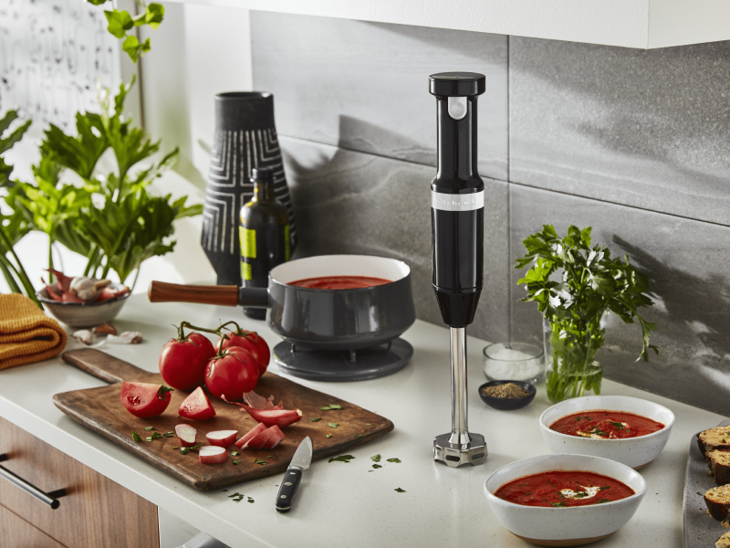 Tomato soup cooking next to an immersion blender Tomato soup cooking next to an immersion blender