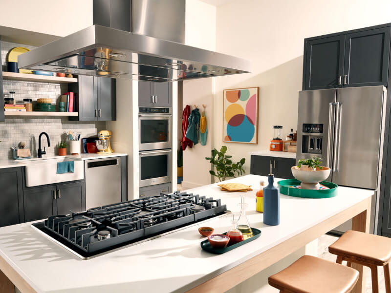 KitchenAid® wall oven, cooktop, range hood, dishwasher and refrigerator appliance suite in a modern kitchen KitchenAid® wall oven, cooktop, range hood, dishwasher and refrigerator appliance suite in a modern kitchen