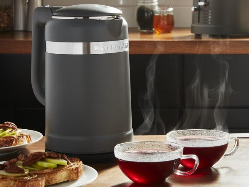 Electric tea kettle on a kitchen island next to cups of tea and toast. Electric tea kettle on a kitchen island next to cups of tea and toast.