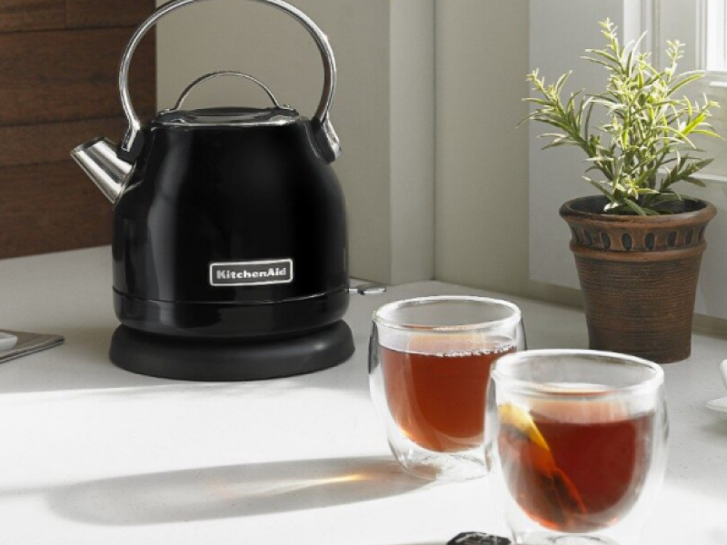 Black KitchenAid® 1.25 L Electric Kettle on a counter next to full cups of tea. Black KitchenAid® 1.25 L Electric Kettle on a counter next to full cups of tea.