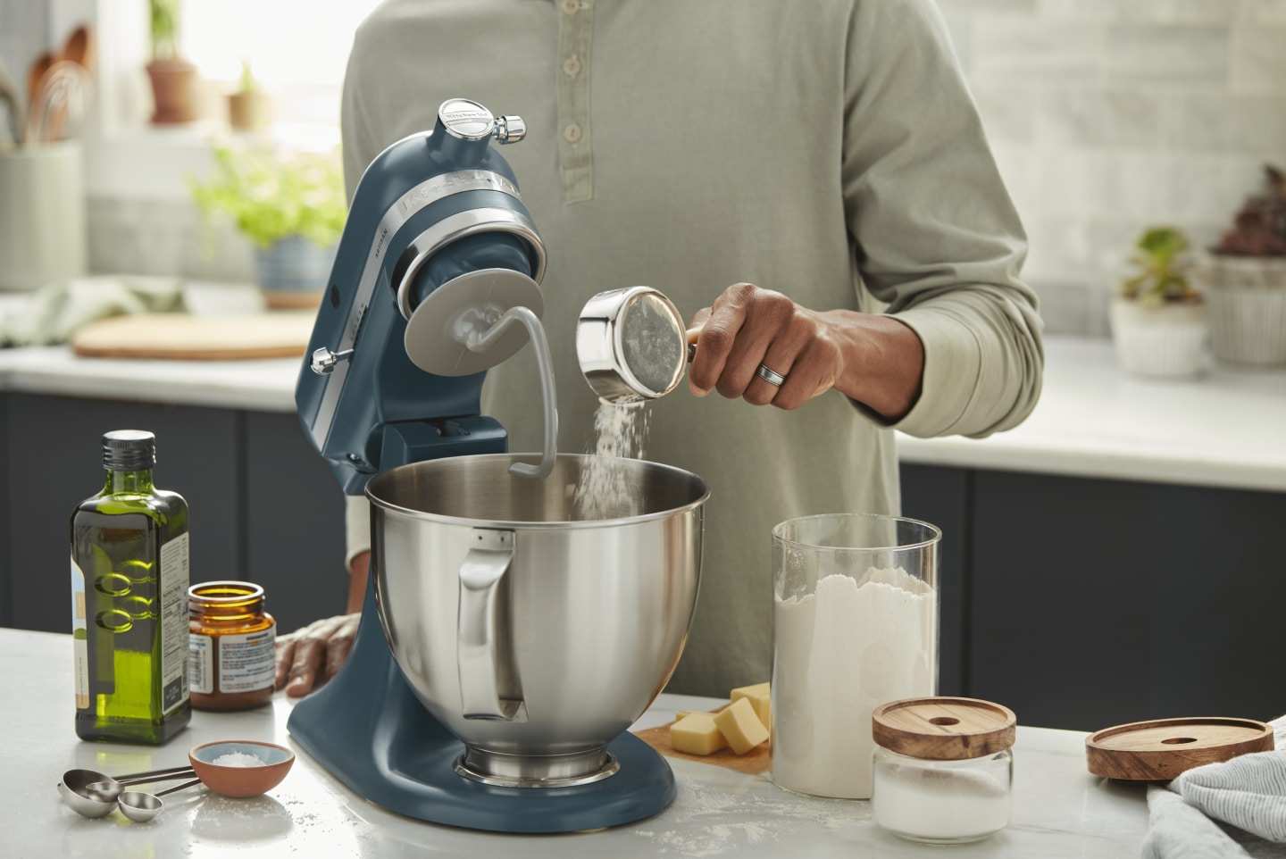 Person adding ingredients into a KitchenAid® stand mixer Person adding ingredients into a KitchenAid® stand mixer