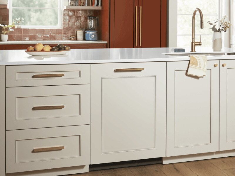 White countertop and cabinetry with gold details, including gold faucet in sink
