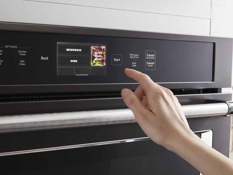 Person selecting a cook setting on a KitchenAid® oven control panel