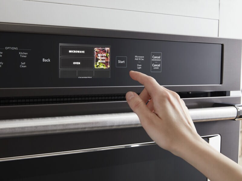 Person selecting a cook setting on a KitchenAid® oven control panel