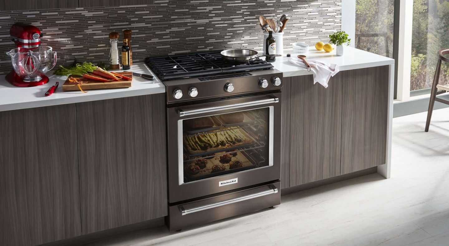A minimalist kitchen shown with a gas slide-in convection range