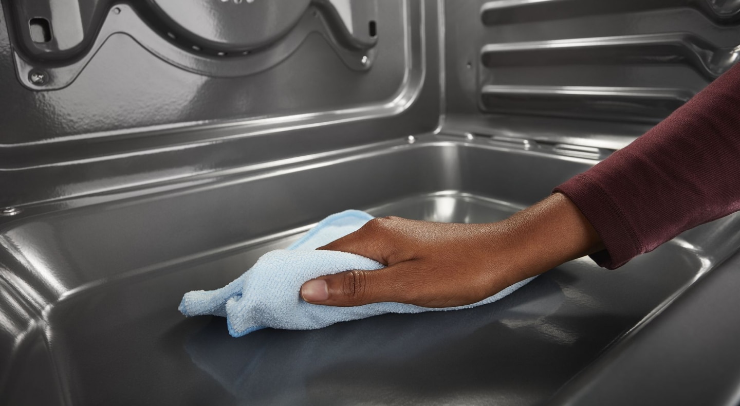 Person cleaning the inside of an oven Person cleaning the inside of an oven