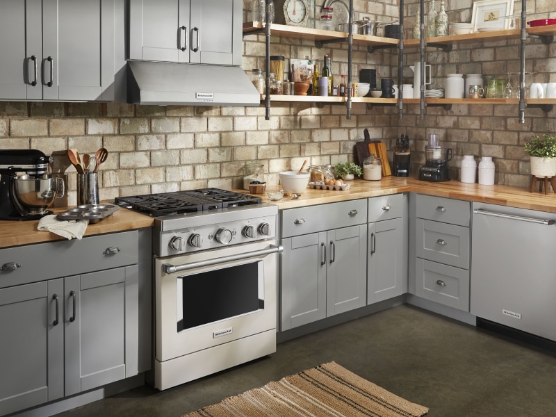 Stainless steel KitchenAid® gas range in a rustic kitchen Stainless steel KitchenAid® gas range in a rustic kitchen