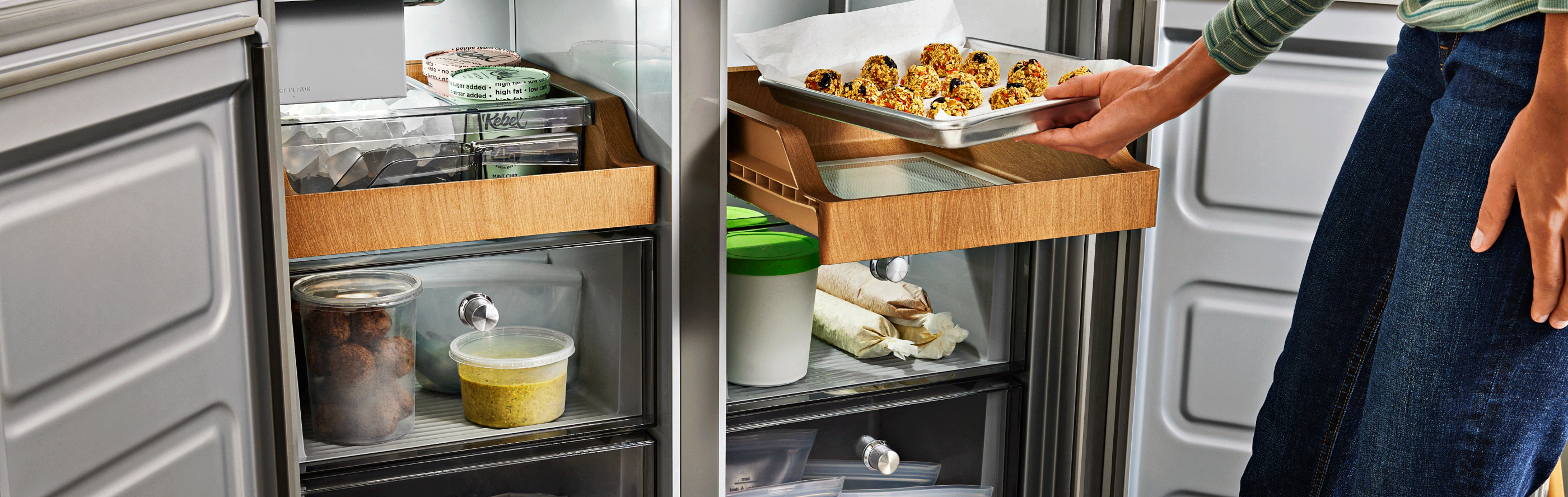 Person placing a tray of cookie dough in the refrigerator