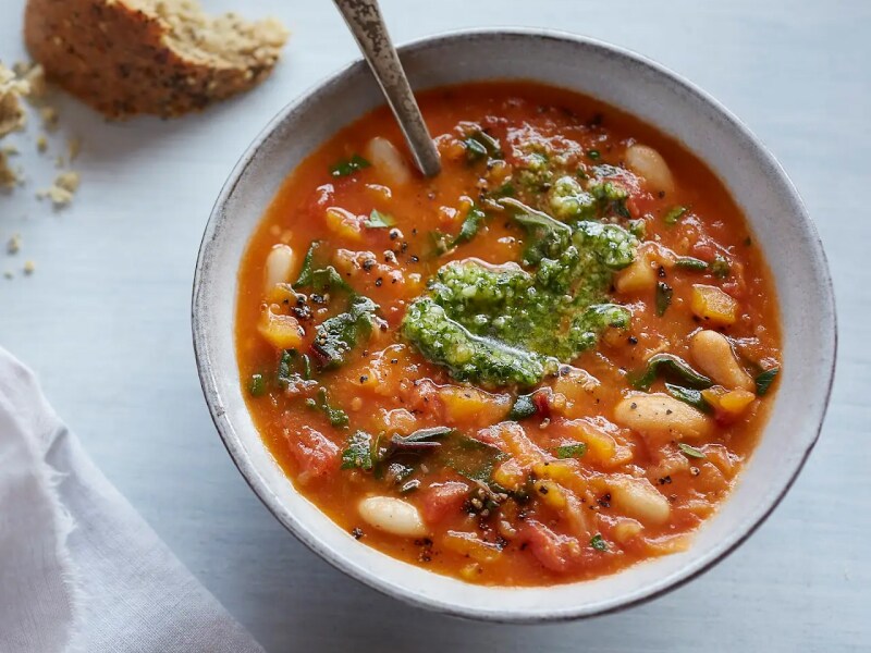 Tuscan bean and pumpkin soup with parsley pesto in bowl with spoon