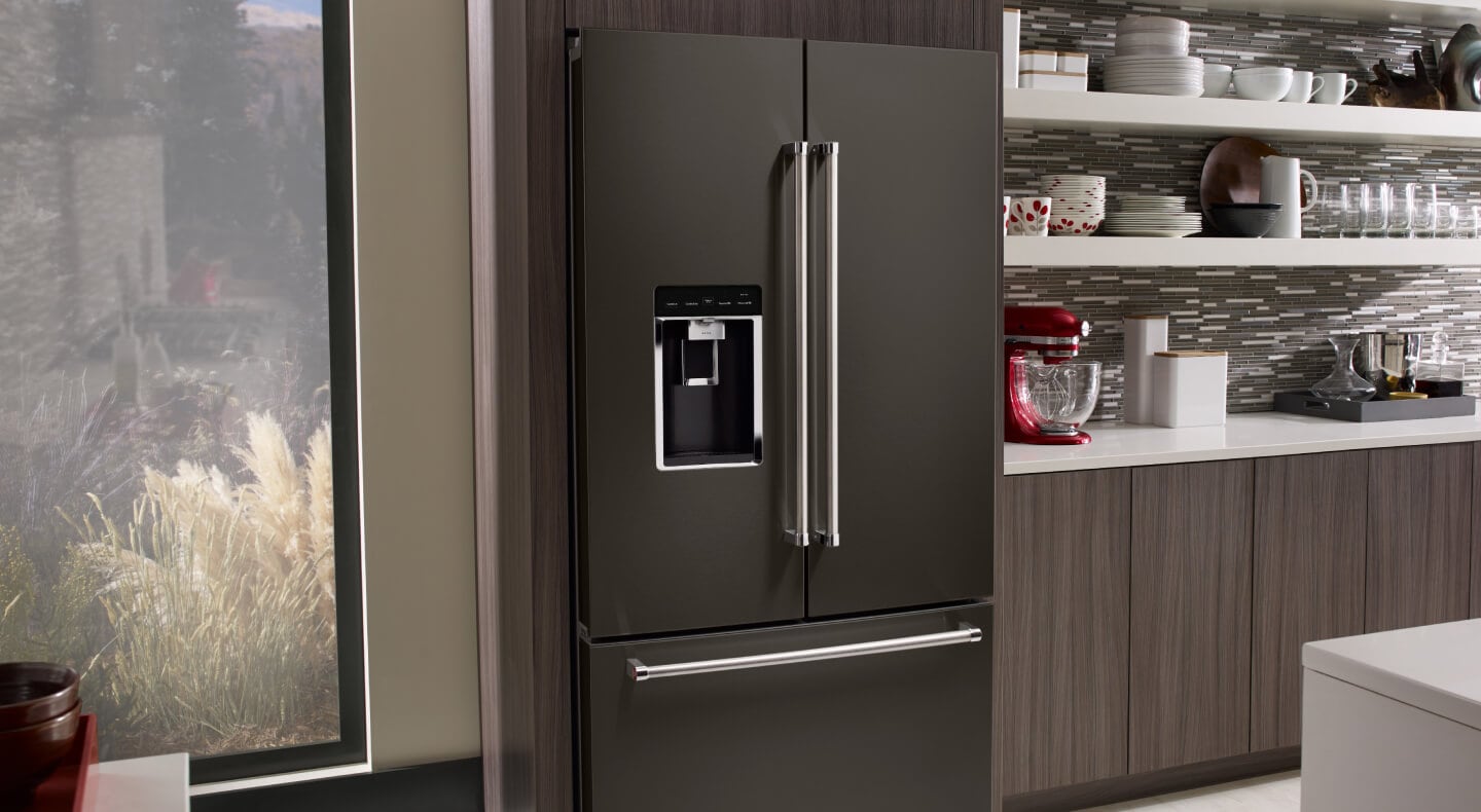 Gray KitchenAid® built-in French door refrigerator next to dishes on floating shelves