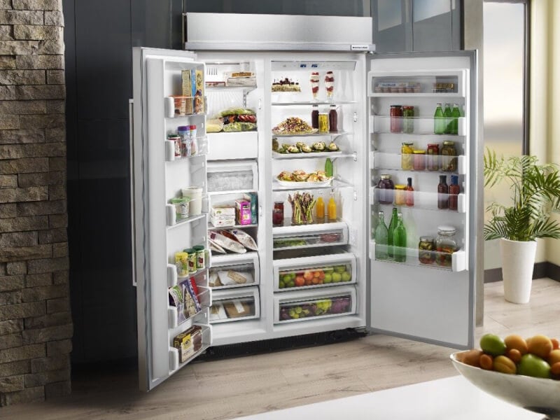 Open KitchenAid® side-by-side refrigerator stocked with fresh food platters Open KitchenAid® side-by-side refrigerator stocked with fresh food platters