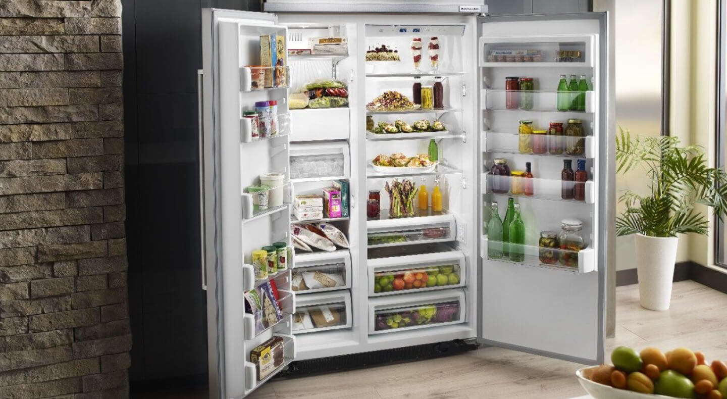 Open KitchenAid® side-by-side refrigerator stocked with fresh food platters Open KitchenAid® side-by-side refrigerator stocked with fresh food platters