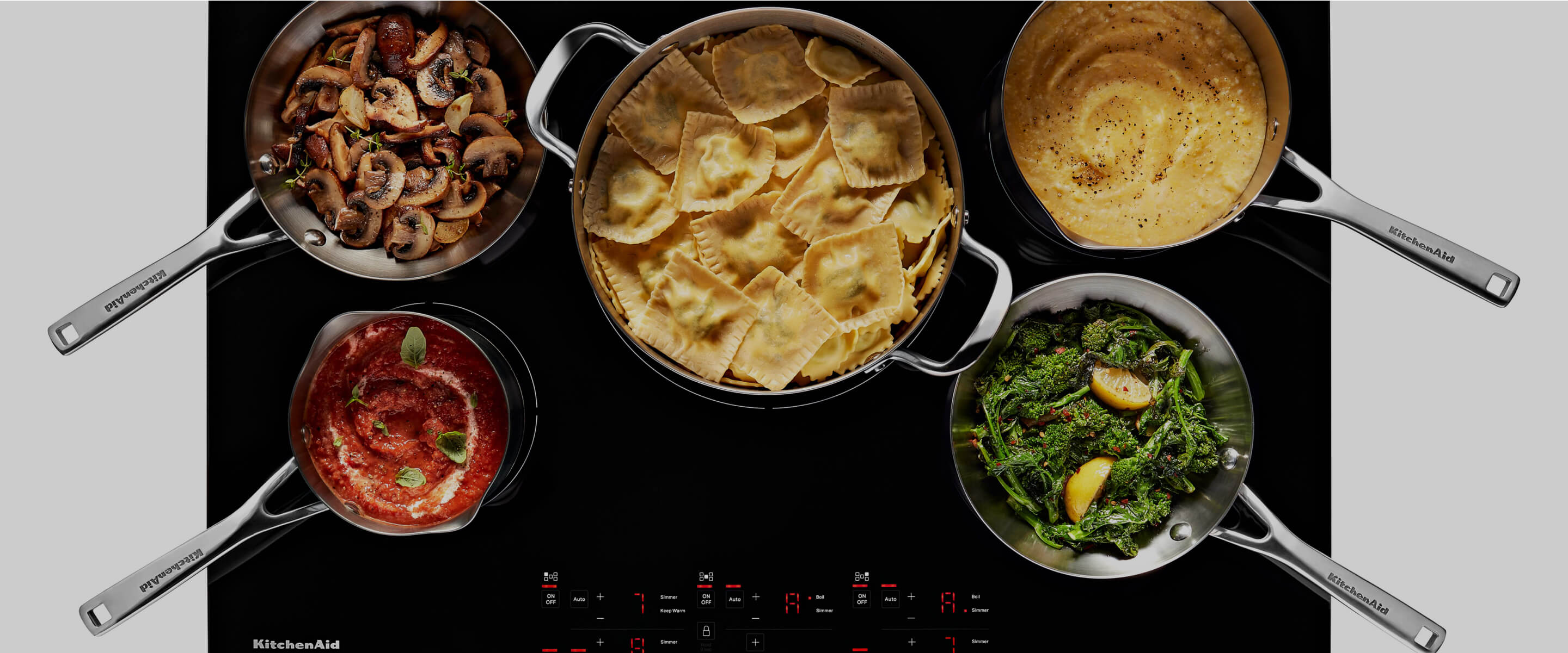 A variety of dishes cooking on an induction cooktop.