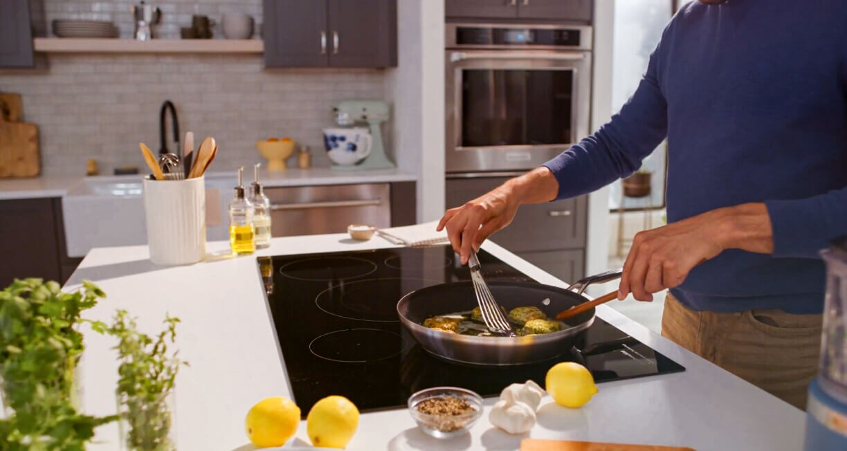 A person cooking at an induction cooktop.