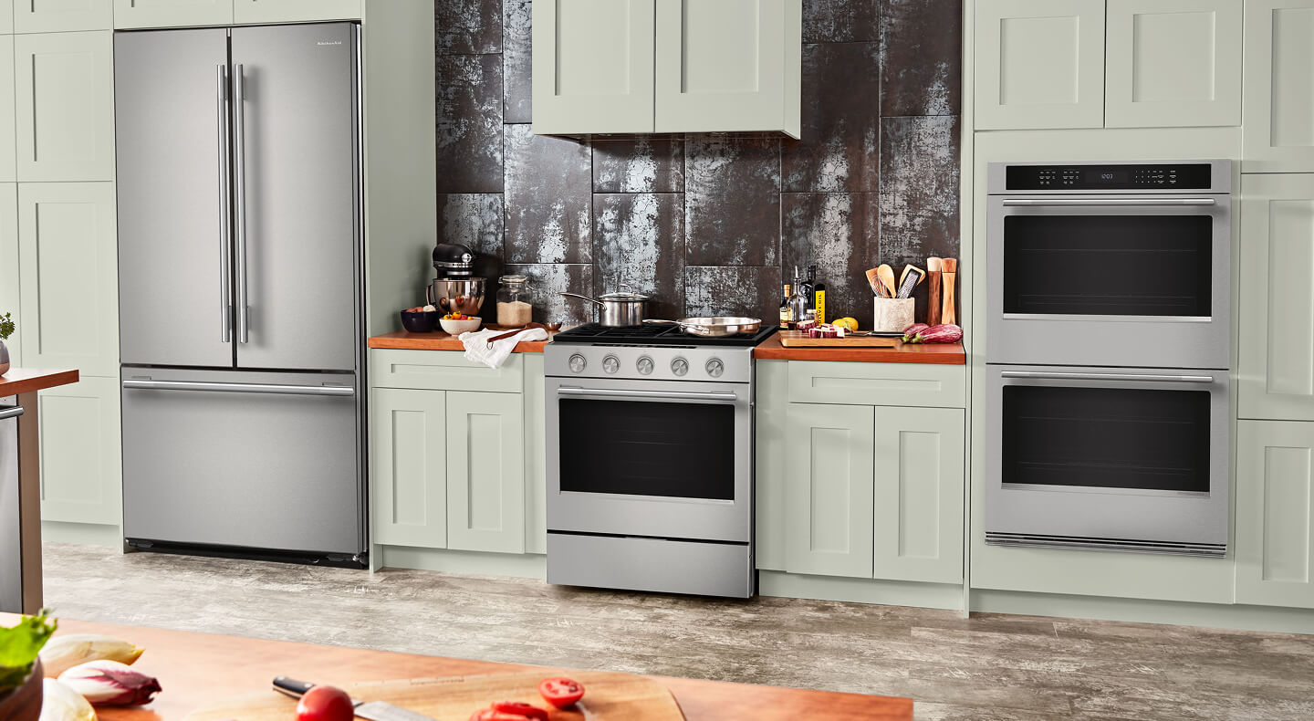 A bright kitchen with matching stainless steel appliances and a KitchenAid® double wall oven