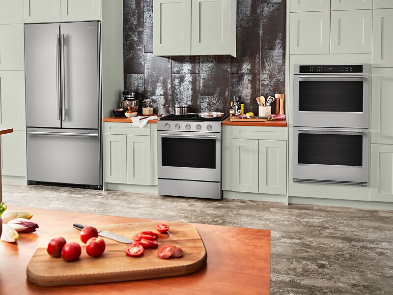 A bright kitchen with matching stainless steel appliances and a KitchenAid® double wall oven