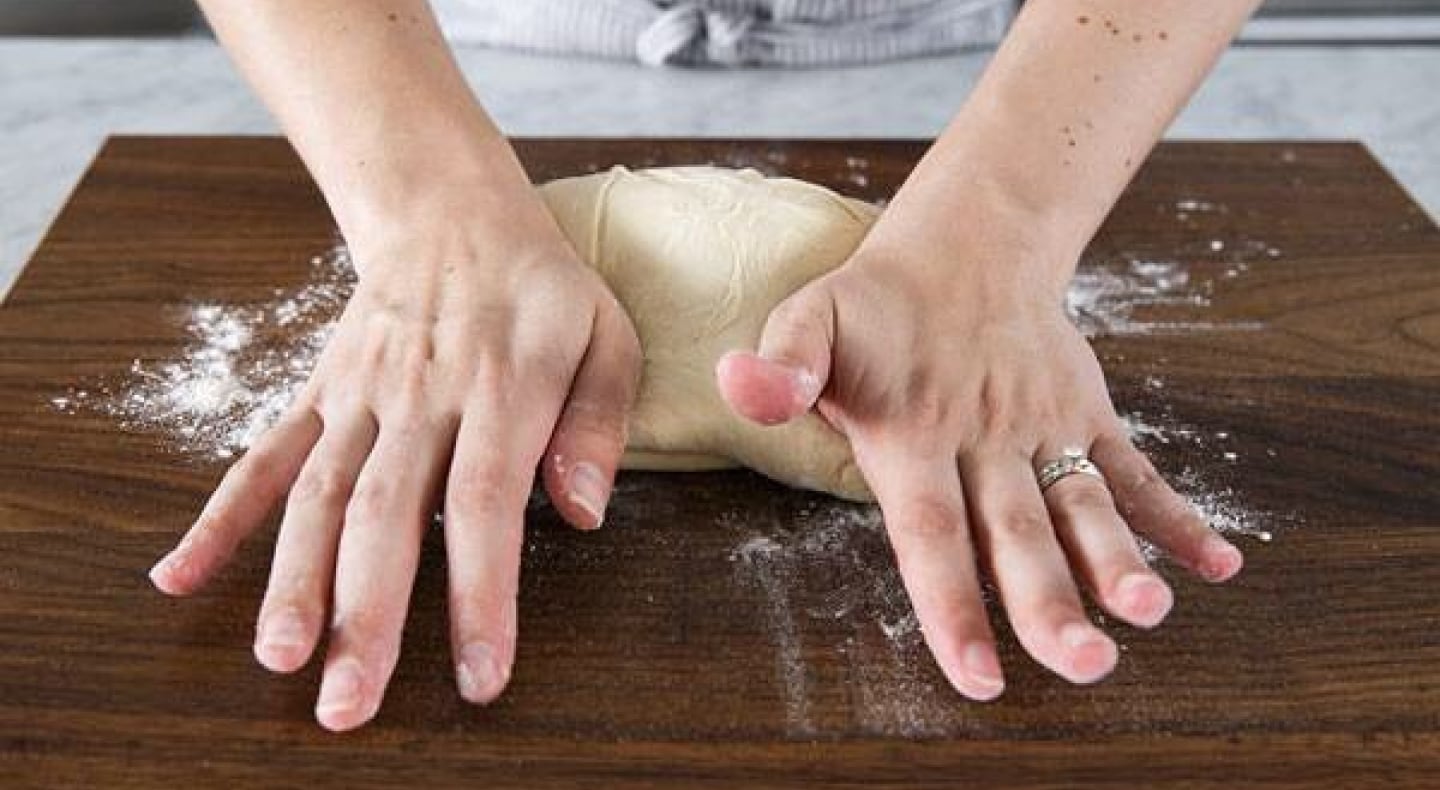 A person kneading bread by hand A person kneading bread by hand