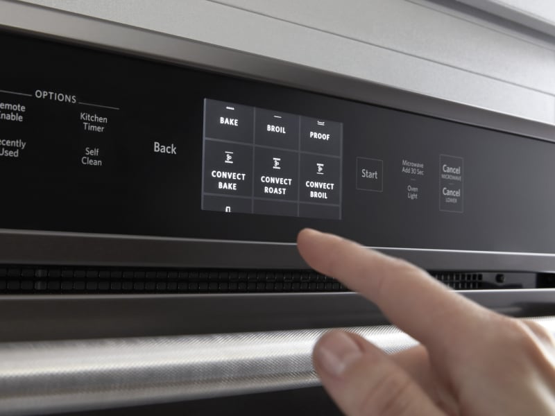 A person making an oven cycle selection