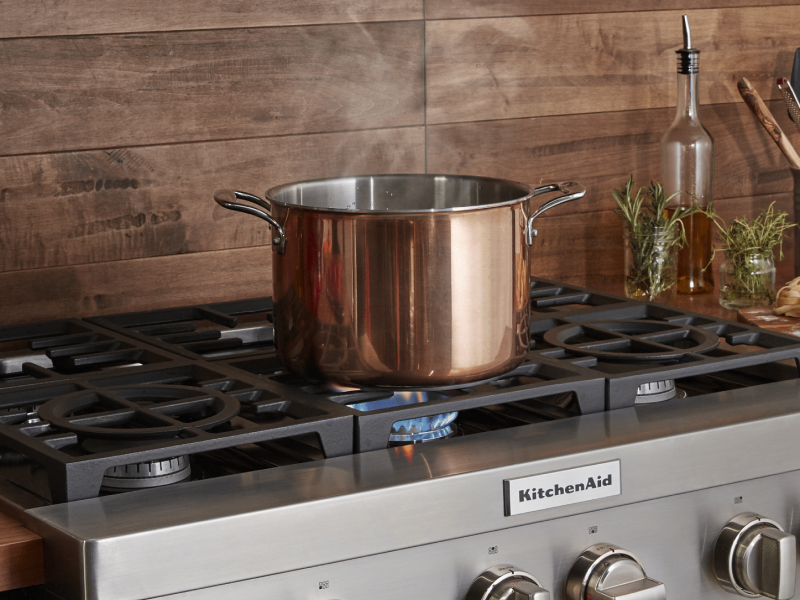 Pot sitting on a gas stove top heating above a flame