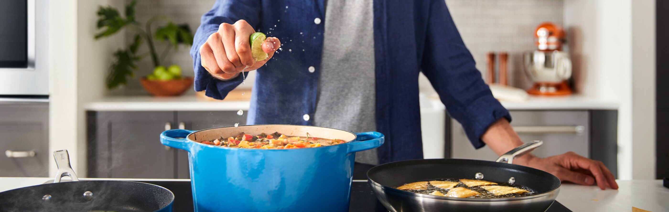 Person squeezing lime into a stock pot over the stove