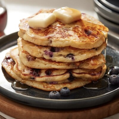 Plate of blueberry pancakes topped with syrup and butter