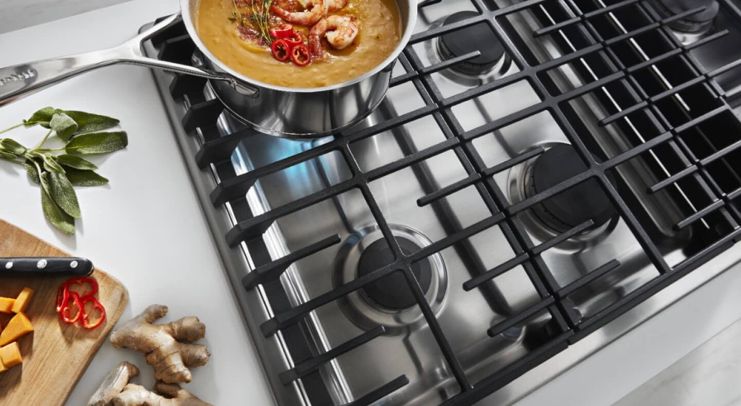 An overhead view of a KitchenAid® gas cooktop simmering a pot of food An overhead view of a KitchenAid® gas cooktop simmering a pot of food