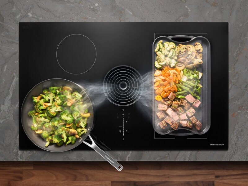 Food cooking on a cooktop with steam rising from it