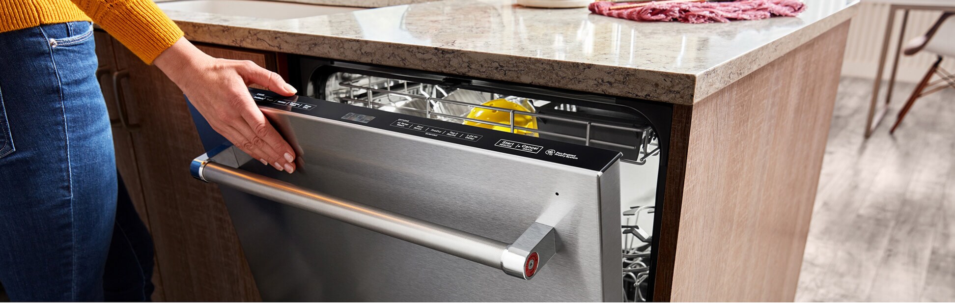 Person closing a KitchenAid® top control dishwasher