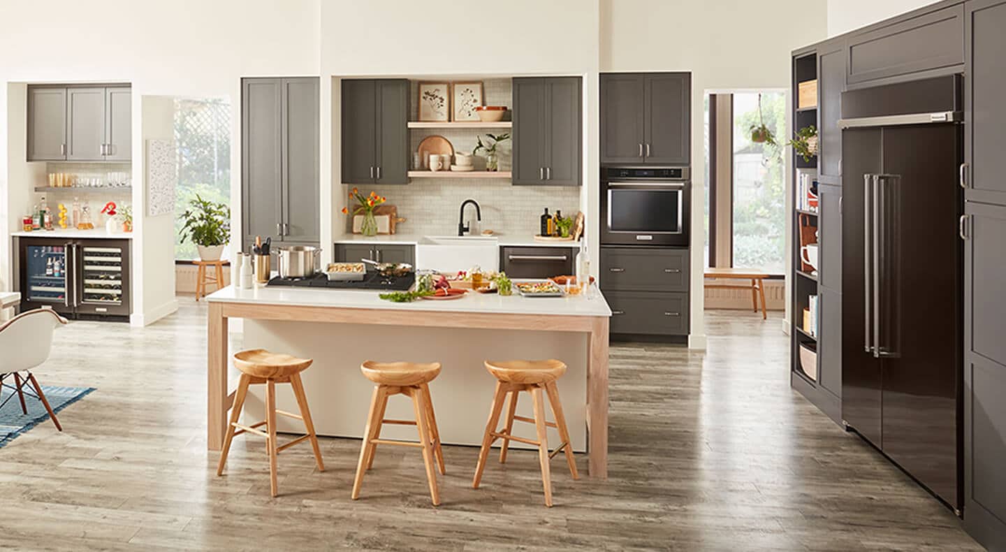 An open-concept kitchen with dark cabinetry and appliances