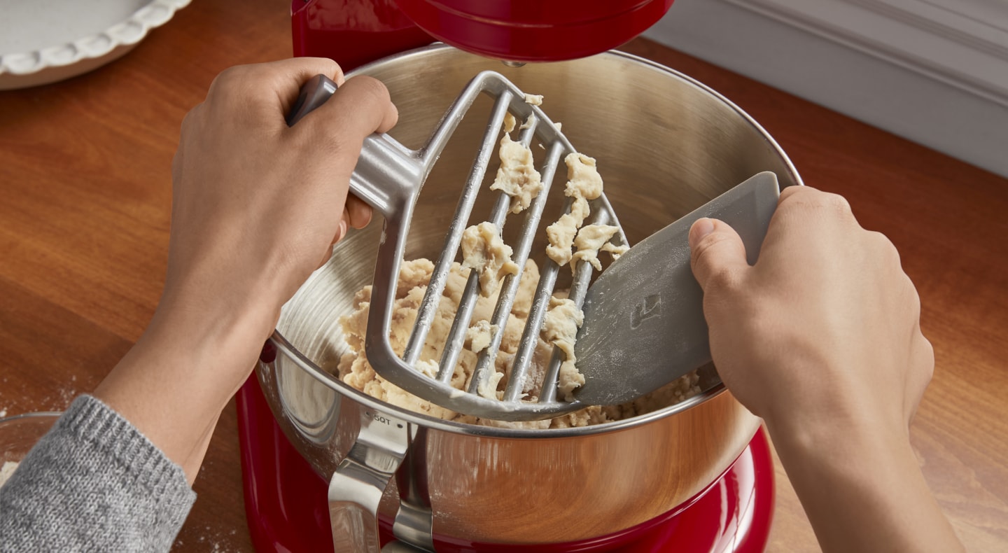 Dough being removed from a pastry beater Dough being removed from a pastry beater