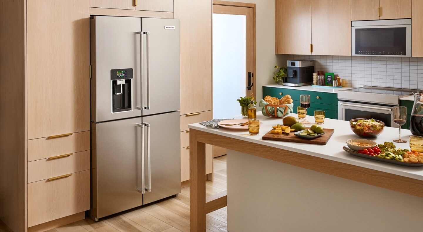 A 4-door refrigerator in a kitchen with wooden cabinetry and a kitchen island