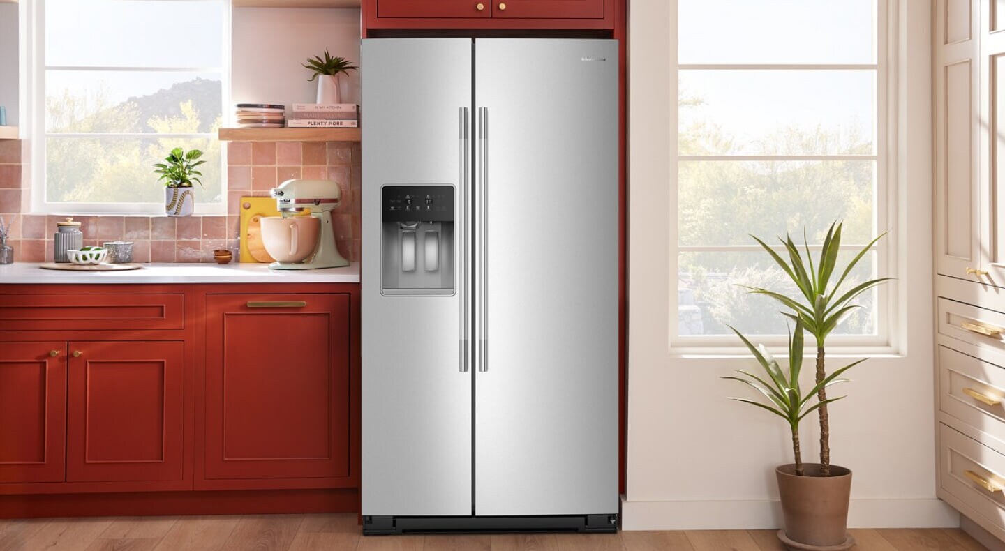  A stainless steel French door refrigerator surrounded by red cabinetry