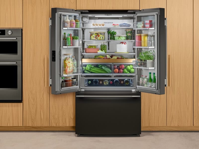 A black stainless steel refrigerator with French doors that are open and exposing food