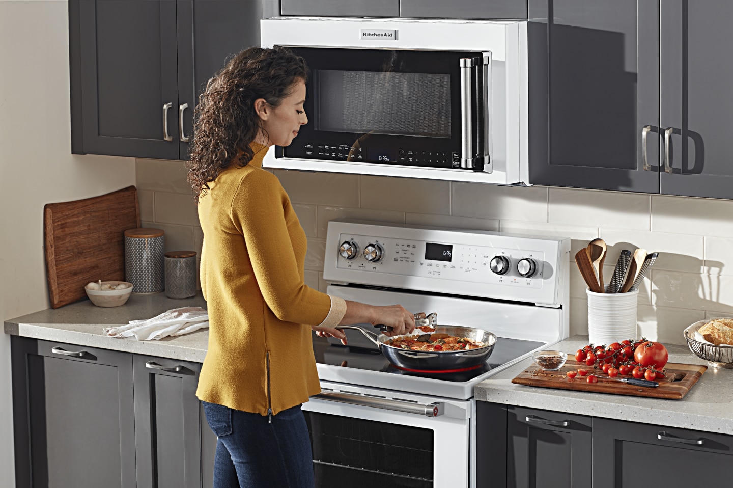 Person adding ingredients to a skillet on an electric stovetop Person adding ingredients to a skillet on an electric stovetop