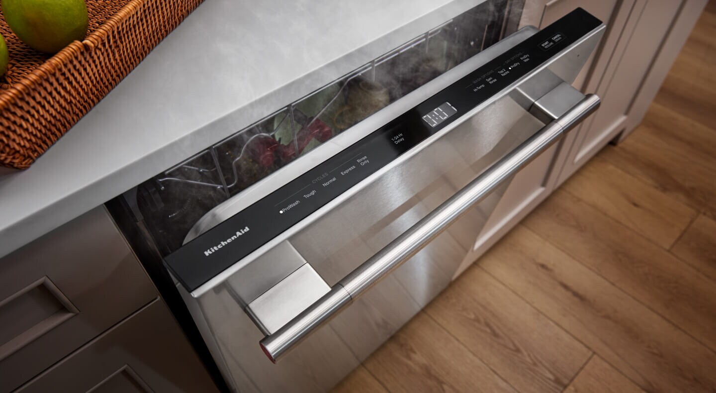 A built-in dishwasher with door slightly open to reveal top controls