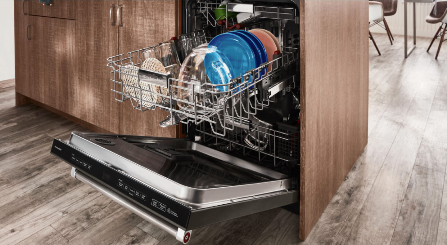 Opened dishwasher with top rack full of colored plates