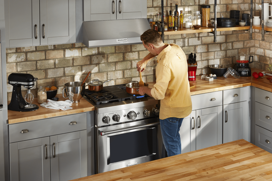 Man stiring a pot on a commercial-style gas range Man stirring a pot on a commercial-style gas range