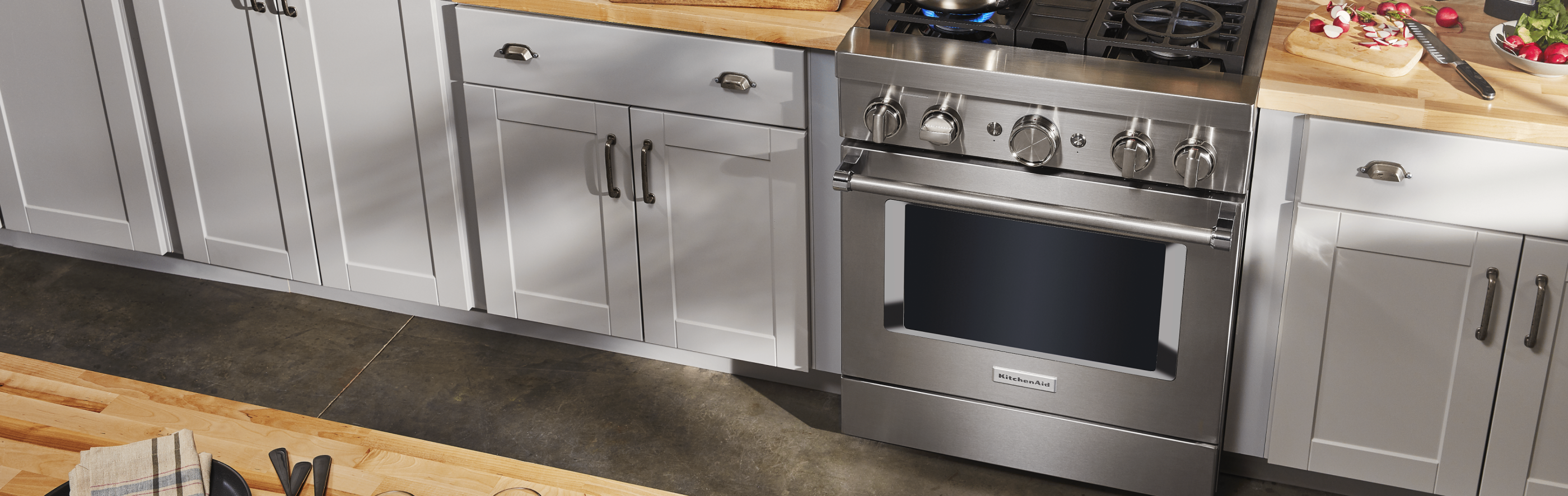 Stainless steel commercial-style range in a grey kitchen